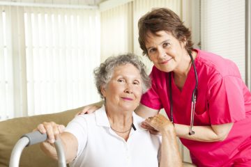 Friendly nurse cares for an elderly woman in a nursing home.